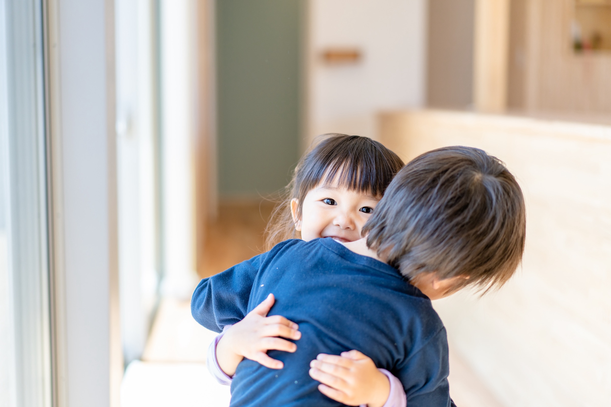 抱き合って笑う2人の子ども