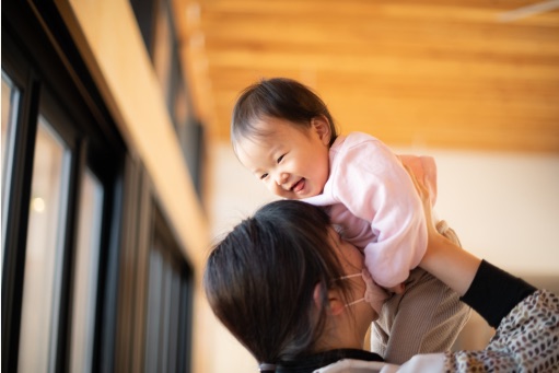 先生に高く抱き上げられて笑う子ども